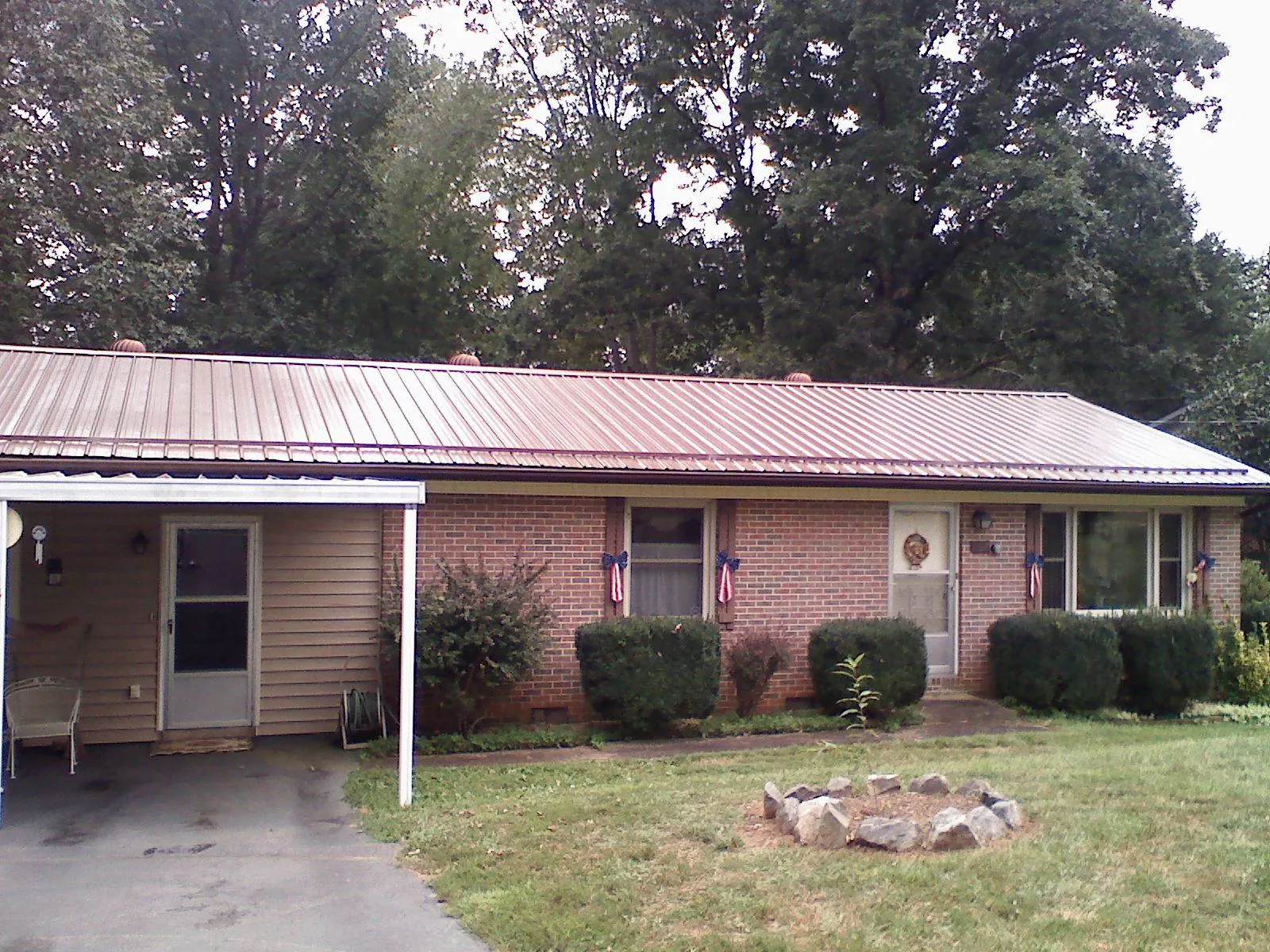 Bronze metal roof and carport on a brick ranch home — Roof Repair work by our crew in Valencia